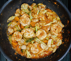 Close up Thai spicy stir fry vegetables and shrimps with spicy red curry paste on a pan, Top view of Thai spicy food
