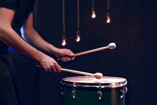 The Drummer Plays With Mallets On Floor Tom In Dark Room.