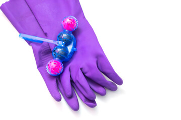 Person in purple protective rubber gloves holds multi-colored balls of toilet bowl cleaner. isolated on white background isolation. Selective focus, close-up