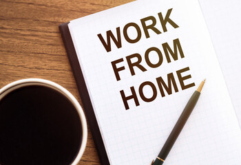 WORK FROM HOME - text on notepad on wooden desk.