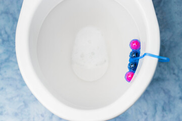 Clean toilet bowl with a cleaning and refreshing balls. Multi-colored balls of toilet bowl cleaner