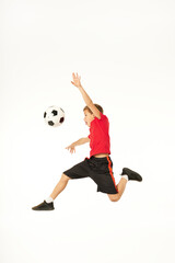 Fototapeta na wymiar Adorable male child jumping and playing football