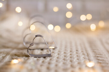 Valentine's Day Cookie Cutters. Heart form on the wool background with light bokeh