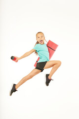 Cute girl with yoga mat and bottle of water jumping and screaming