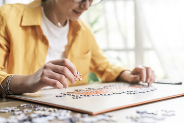 Woman sitting at desk and solving a puzzle