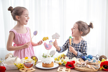 Obraz na płótnie Canvas Two little girls decorate a festive cake for the Easter holiday.