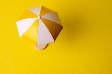 multicolored beach umbrella on yellow background