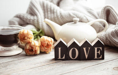 Fototapeta na wymiar A cozy composition for Valentine's Day with the decorative word love and decor details.