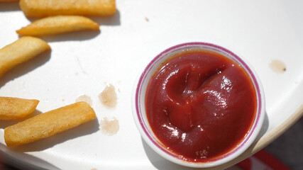 Eating french fries, potato chips with ketchup. Junk food, fast food concept. Top of view