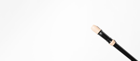 Black flute on a white background, flat lay. Banner, copy space. Music education, concert concept