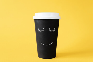 Good morning with coffee. Disposable cup of coffee with painted smiling face. Cheerful morning, invigorating drink, love for coffee concept