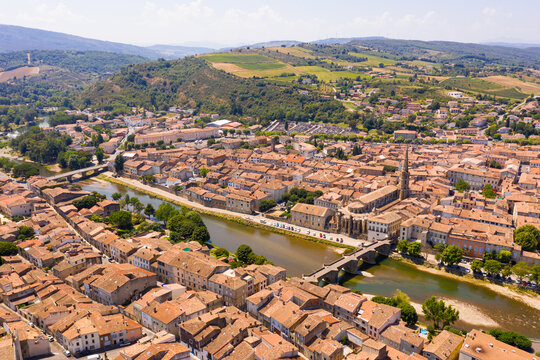 Scenic aerial view of French commune of Limoux on Aude River overlooking gothic spire of Church of Saint Martin in summer, Occitanie