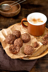 Chocolate coconuts. Chocolate balls with coconut. Chocolate candies or cookies with coconut, cinnamon and powdered sugar