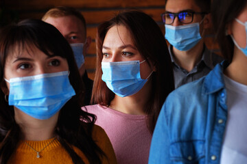 Crowd of masked people during the covid-19 pandemic - The faces of young people wearing medical masks - Sad faces of people from the covid epidemic