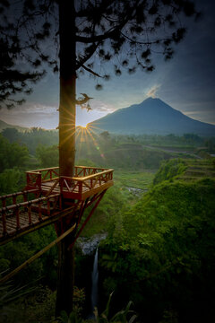 sunrise in the Kedung Kayang waterfall, and Merapi mountains as the background