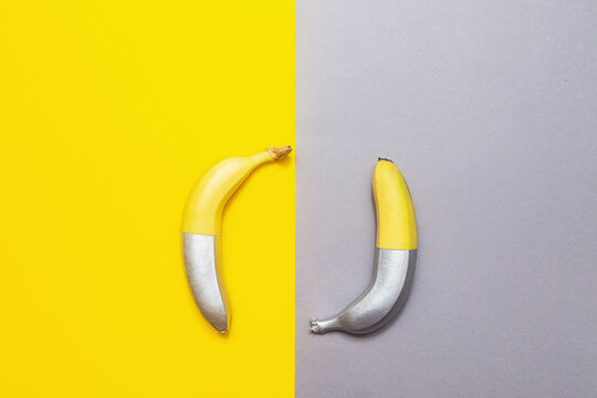 Painted silver bananas on a yellow-gray background. Minimalistic abstract food image