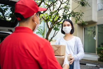 Delivery man handing box of parcel post to Caucasian female customer.