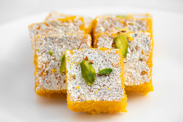 Famous Indian Mithai Moong Dal Burfi Barfee Or Meetha Mung Daal Barfi Made Of Yellow Gram Flour In Desi Ghee Mixed With Mawa Pistachio And Khoya. Isolated On White Background With Space For Text