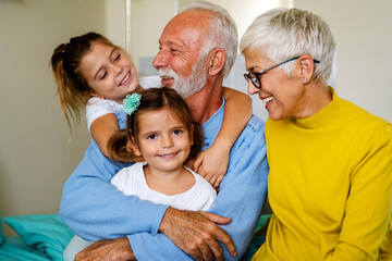 Happy mature couple having fun in love with their grandchildren