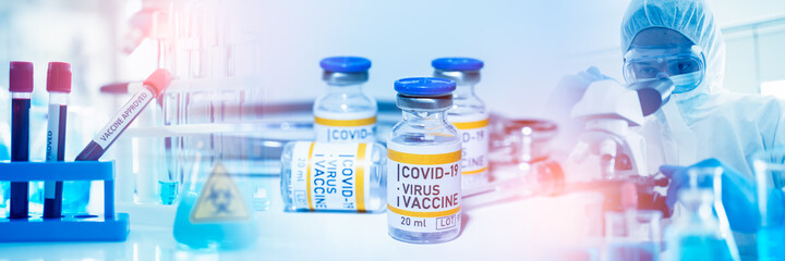 Vaccine research and Medicine infectious coronavirus 19 concept.scientist in biohazard protection clothing analyzing covid 19 in blood sample tube for test vaccine with microscope in laboratory