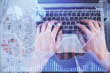 Obraz na płótnie Canvas Double exposure of man's hands typing over laptop keyboard and forex chart hologram drawing. Top view. Financial markets concept.