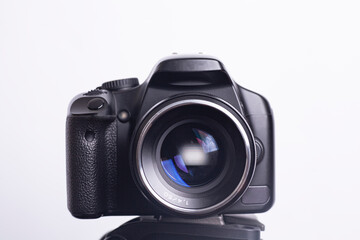 Digital photo camera on black tripod isolated on white background