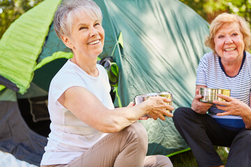 Glückliche Seniorinnen morgens vor dem Zelt