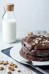 Chocolate and brownie cake witha bottle of milk, nuts and a fork