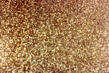 Abstract gold glitter and shimmer background with bokeh effect. Background for festive design, new year and christmas. Stock photography. 