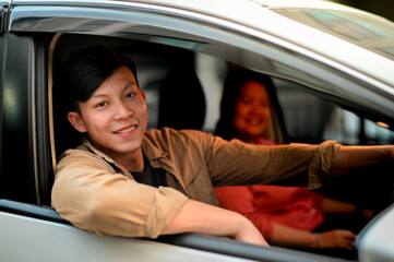 Young asian  man smiling in his car.