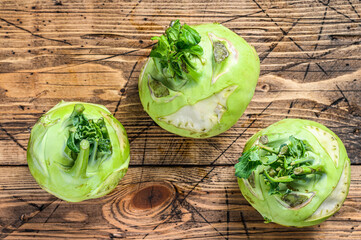 Heads of fresh ripe white cabbage kohlrabi. Wooden background. Top view