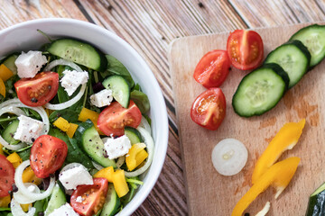 Green vegan salad made from a mixture of green leaves and vegetables.