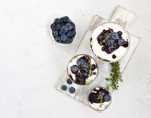 Tiramisu. Homemade dessert in glasses with blueberries, cream and ladyfingers garnish with...