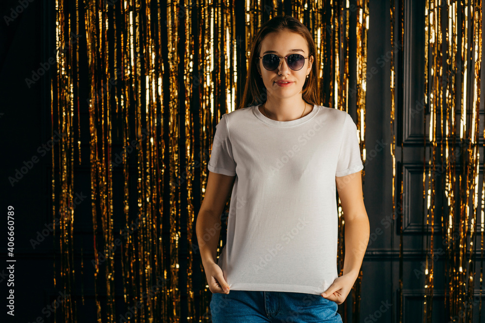 Poster Stylish girl wearing white t-shirt and sunglasses posing in studio