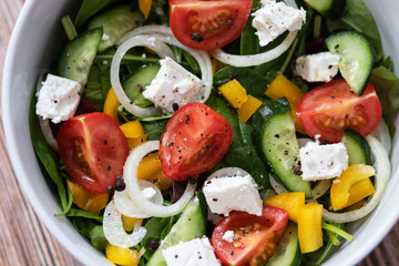 Green vegan salad made from a mixture of green leaves and vegetables.