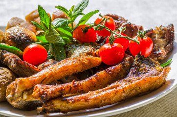Fresh, homemade grilled beef skewers with vegetables and spices, with barbecue sauce and ketchup, on a white plate close-up