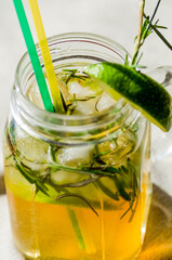 Lemon lemonade in mason jar glass ofwith lemons and straw on tab