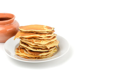 Breakfast.A stack of pancakes in a plate and a pot of honey on a white isolated background.Free space.Space for text, horizontal view.