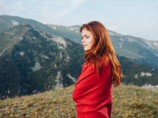 Romantic woman hiding behind a red plaid in the mountains outdoors in nature