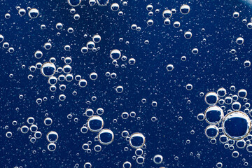 Large beautiful Oxygen bubbles underwater on a blue background macro.