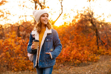 Lovely happy young girl walking in the autumn park