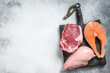 Set of raw meat steaks salmon, beef and chicken. White background. Top view. Copy space