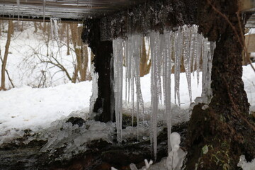 scenic view of long icicles below a wooden construction