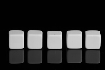 White cubes on a black surface with reflection. Close-up, isolated background.