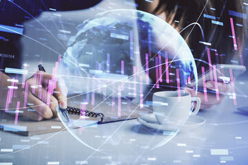 Double exposure of forex graph sketch hologram and woman holding and using a mobile device. Stock market concept.