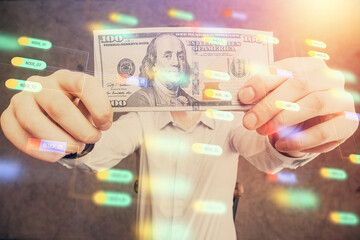 Double exposure of technology drawing hologram and us dollars bills and man hands. Data concept