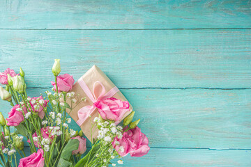 Beautiful spring flowers on light blue wooden background. Festive floral composition with craft paper  gift boxes. Valentine's day, Womans day, mothers day greeting card . Top view flat lay