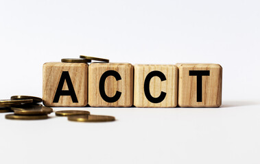 wooden cubes and ACCT, coins, the concept of taxation, increase taxes and fees