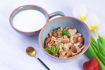 Spelt flakes with milk on breakfast. Light breakfast on Valentine's day with tulips and heart