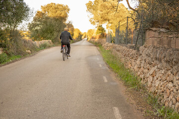 Fototapeta premium Older man with his back turned taking a bike ride